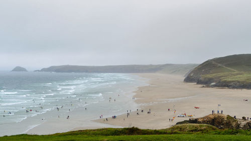 Group of people on beach against sky