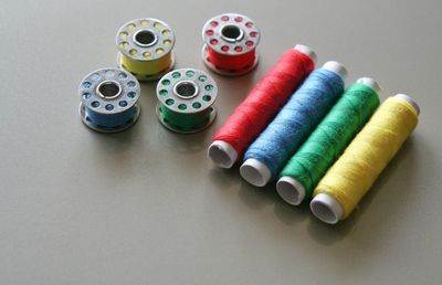 High angle view of thread reels and spools on gray background