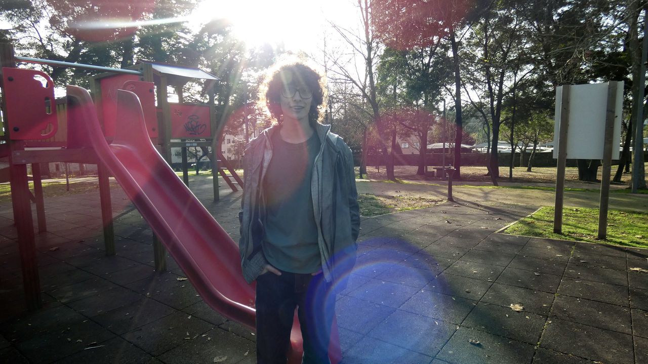 FULL LENGTH OF WOMAN STANDING ON SLIDE AT PARK