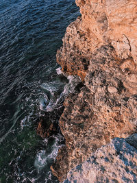 View from the top to the deep of the sea, the water beats on the stones, wave-like background