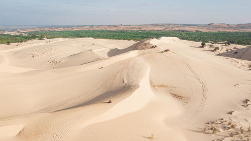 Aerial view of sand dunes at beach against sky