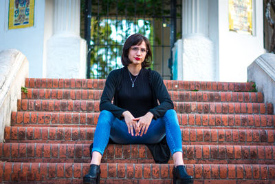 Portrait of young woman sitting on staircase