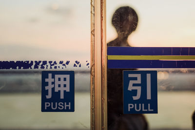 Rear view of man standing against sign