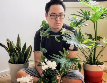 Portrait of young man with potted plants