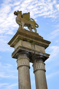 Low angle view of monument against cloudy sky