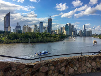 Scenic view of river by buildings against sky