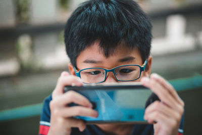 Portrait of boy photographing with mobile phone