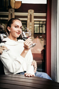 Full length of a young woman drinking glass