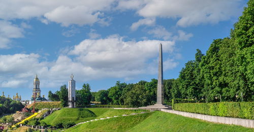 Panoramic view of green landscape against cloudy sky