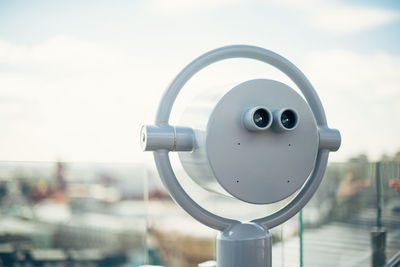 Close-up of coin-operated binoculars against sky