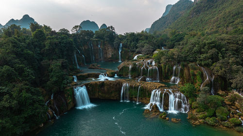 High angle view of waterfall in forest against sky