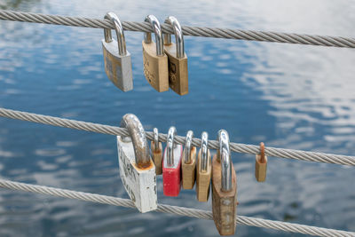 Close-up of padlocks on railing against bridge