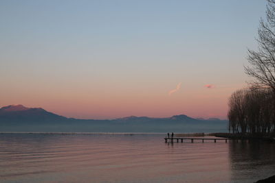 Scenic view of lake against clear sky during sunset