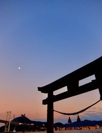 Silhouette built structure against clear sky at sunset