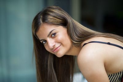 Side view portrait of smiling teenage girl in city