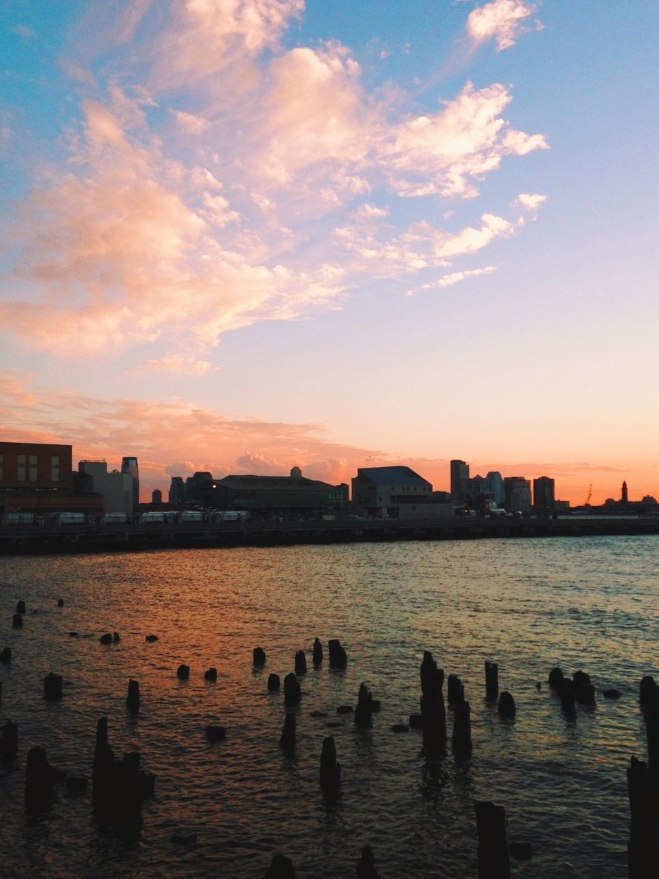 water, sunset, building exterior, architecture, built structure, sky, city, waterfront, silhouette, river, cloud - sky, cityscape, rippled, cloud, sea, reflection, nature, lake, scenics, bird