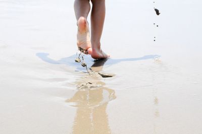 Low section of woman standing on beach