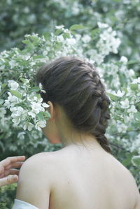 Rear view of young woman sitting on field