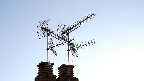 Low angle view of electricity pylon against clear sky