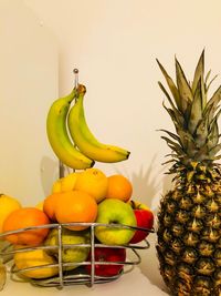 Close-up of fruits in basket against wall