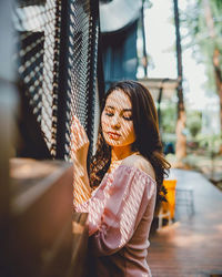 Side view of young woman standing at home