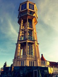 Low angle view of clock tower against cloudy sky