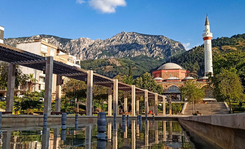 Buildings by mountains against sky