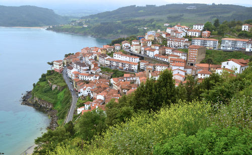 High angle view of town on hill by sea