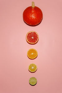 Citrus fruits arranged by its size with pumpkin on top