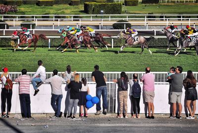 Rear view of people watching horse race