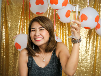 Smiling young woman holding balloons