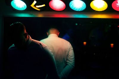 Reflection-rear view of man relaxing at music concert 