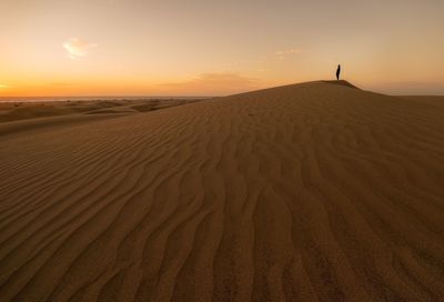 Scenic view of desert against sky during sunset