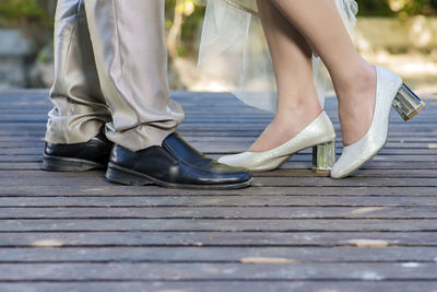 Low section of couple standing on floorboard