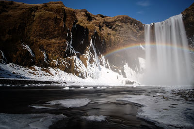 Scenic view of waterfall against sky