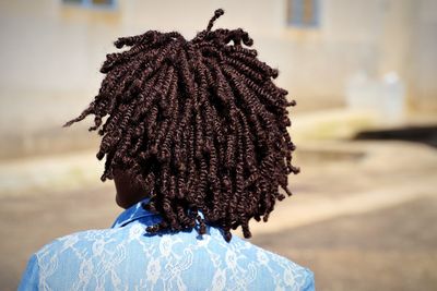 Rear view of man with dreadlocks on sunny day