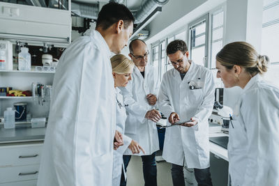 Scientist working with digital tablet while standing at laboratory