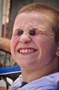 Close-up of playful teenage boy with blueberries