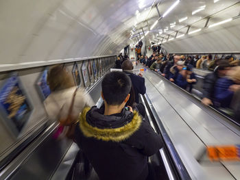 Long exposure of the people frenzy on an underground escalator