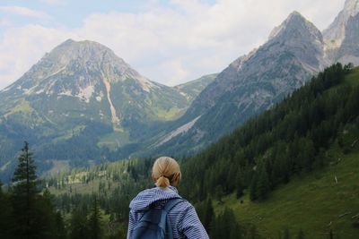 Rear view of woman standing against mountain