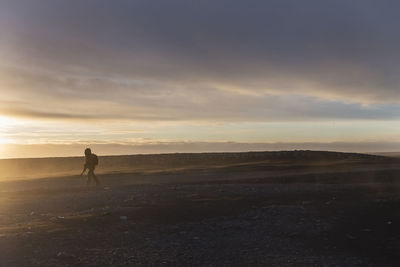 Man walking on landscape against sky