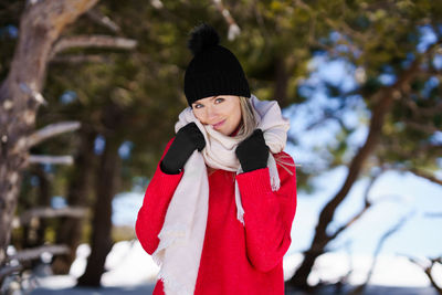 Portrait of smiling woman standing in snow