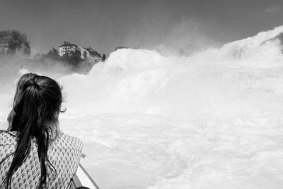 Rear view of woman looking at snowcapped mountains during winter