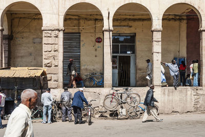 People on street against buildings in city