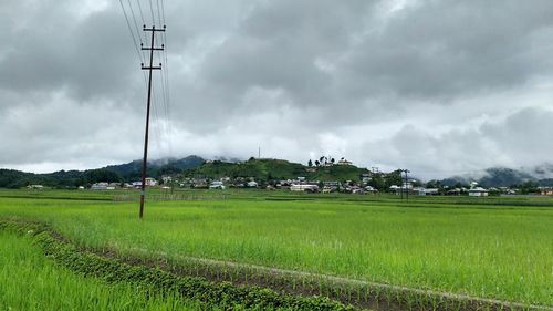 Scenic view of field against cloudy sky