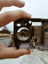 Cropped hand of person holding old camera