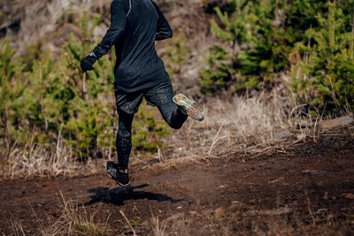 Male runner run down mountain in muddy trail	
