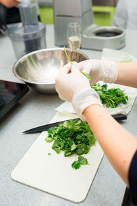 Cropped hand of person preparing food on table