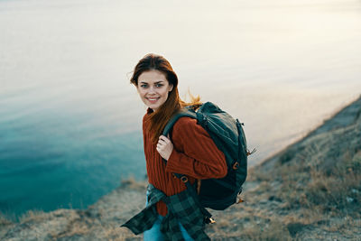 Portrait of smiling young woman standing in water