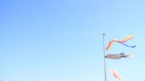 Low angle view of koinobori against clear sky